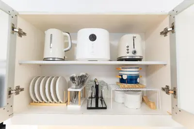 a kitchen pantry with dishes and appliances on shelves at 2mins to Malls, Unli Full Body Massage, Eastwood Le Grand 3 in Manila