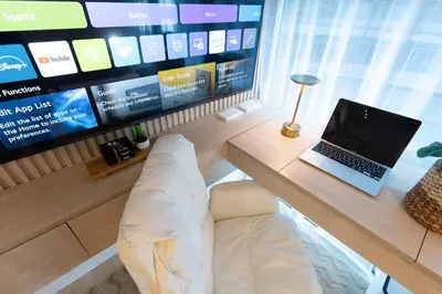 a laptop sitting on a desk in front of a tv at 2mins to Malls, Unli Full Body Massage, Eastwood Le Grand 3 in Manila
