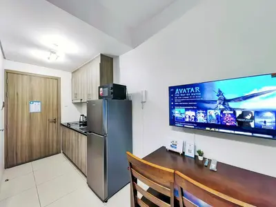 a kitchen with a stainless steel refrigerator and a table at 1BR Condotel with Balcony at FAME Residences #FM06-1 in Manila