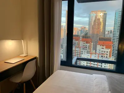 a room with a bed and a desk and a window at Makati City Ayala Ave Extension Condo with Fast Internet in Manila