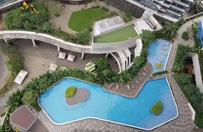 an overhead view of a building with two swimming pools at Makati City Ayala Ave Extension Condo with Fast Internet in Manila