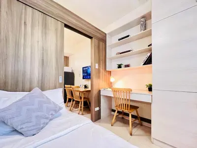 a bedroom with a bed and a desk and a table at 1BR Condotel with Balcony at FAME Residences #FM15-1 in Manila
