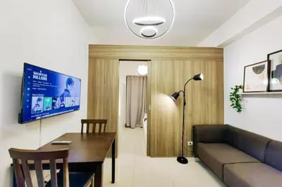 a living room with a couch and a table and a tv at 1BR Condotel with Balcony at FAME Residences #FM17-1 in Manila