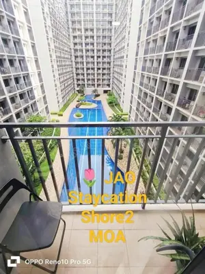 a view of the pool from the balcony of a apartment at JAO Cozy Stay - Mall of Asia in Sampong
