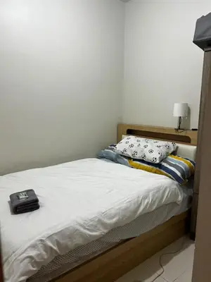 a bed with two pillows on top of it at Bakshi Lovely Haven 3 in Manila