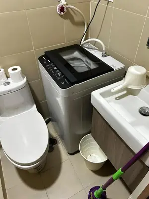 a bathroom with a toilet and a sink with a microwave at Bakshi Lovely Haven 3 in Manila