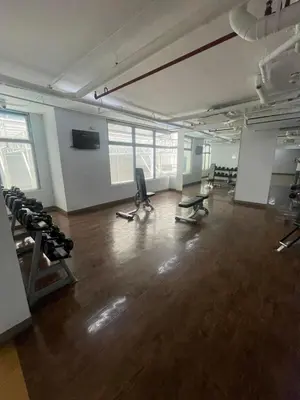 an empty room with a gym with chairs and weights at Makati City The Serenity Tower 2512A in Manila