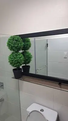 a bathroom with a toilet and two potted plants at House of Lilith at Kasara in Manila
