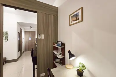 a room with a desk with a lamp and a hallway at 1BR Condotel with Balcony at FAME Residences #FM21-1 in Manila