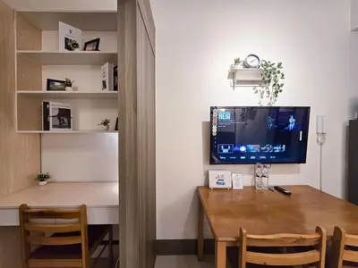a room with a desk with a computer and a table at 1BR Condotel with Balcony at FAME Residences #FM22-1 in Manila