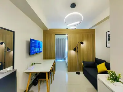 a living room with a table and a couch at 1BR Condotel with Balcony at FAME Residences #FM24-1 in Manila