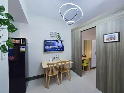 a dining room with a table and a tv on the wall at 1BR Condotel with Balcony at FAME Residences #FM31-1 in Manila