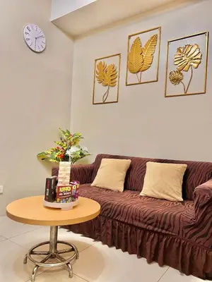 a living room with a brown couch and a table at Fika Staycation in Manila