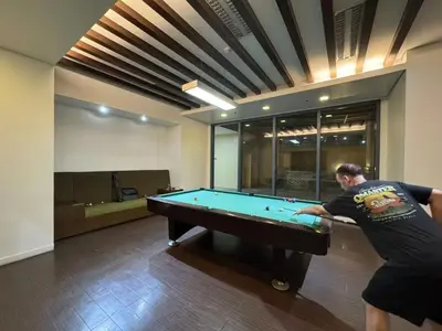 a man playing pool in a room with a pool table at \u5eb7\u5bbf \u6674\u7a97\u5c45 Bright Window Room in Sampong