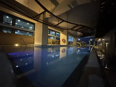a swimming pool in a building at night at \u5eb7\u5bbf \u6674\u7a97\u5c45 Bright Window Room in Sampong