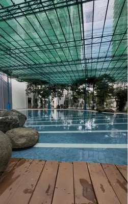a large swimming pool with a green roof at Reign Escape in Manila