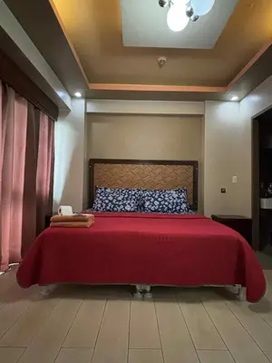 a bedroom with a red bed with a red blanket at Rooms Across NAIA Terminal 3 Pasay in Manila