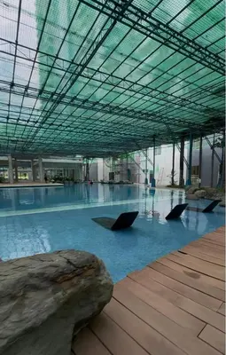 a large building with a swimming pool with umbrellas at The Fresh Escape 2 in Manila