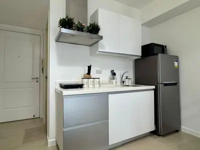 a kitchen with white cabinets and a refrigerator at SM Bicutan by Bahamas in Manila