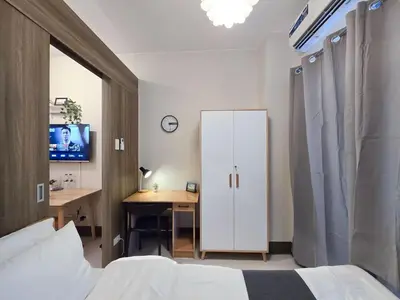 a bedroom with a bed and a desk with a tv at 1BR Condotel with Balcony at FAME Residences #FM32-1 in Manila