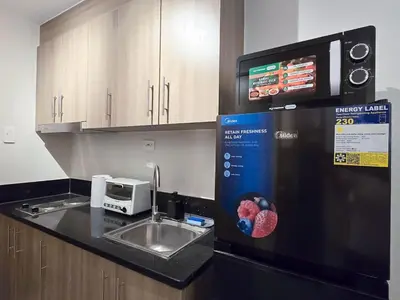 a kitchen with a sink and a microwave at 1BR Condotel with Balcony at FAME Residences #FM32-1 in Manila
