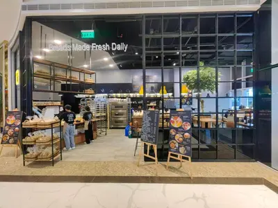 a store front of a bakery with a person standing inside at 1BR Condotel with Balcony at FAME Residences #FM32-1 in Manila