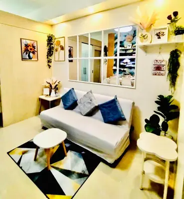a living room with a couch and two tables at Comfystay at Sea Residences in Manila