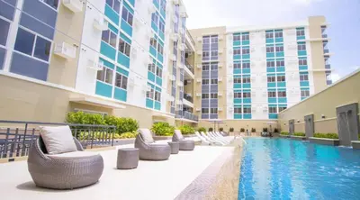 a hotel swimming pool with chairs and a building at Casa Gianna at Berkeley Suites, South Forbes in Silang