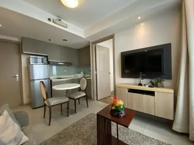 a living room with a table and a kitchen at Makati 1BR High Floor in Manila