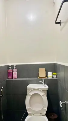 a bathroom with a white toilet and a sink at The Cozy Fabb in Manila