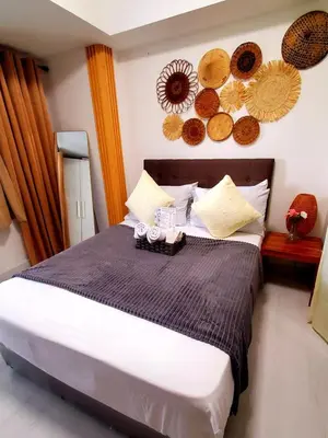 a bedroom with a bed with plates on the wall at Azurejulz Dream Staycation in Manila