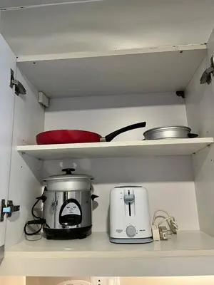 a kitchen with a toaster and a slow cooker at Cozy 1br unit in Uptown BGC in Manila
