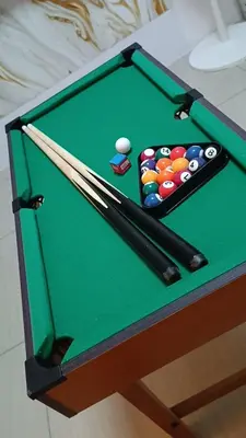 a green pool table with cue balls and bats at Staycation Zone in Manila