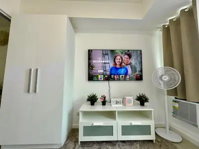 a living room with a flat screen tv on a wall at SM Bicutan Escape Staycation in Manila