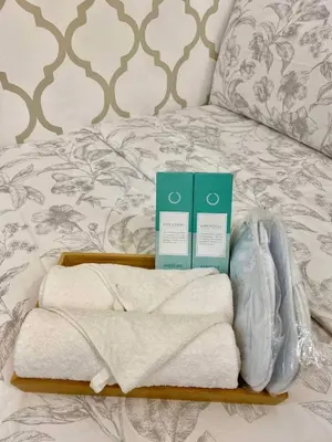 a tray with towels and books on a bed at The Lay-by Fame MRT Megamall Greenfield Greenhills in Manila