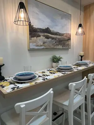 a dining room table with chairs and a painting at The Lay-by Fame MRT Megamall Greenfield Greenhills in Manila