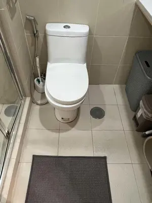 a bathroom with a white toilet and a shower at The Lay-by Fame MRT Megamall Greenfield Greenhills in Manila