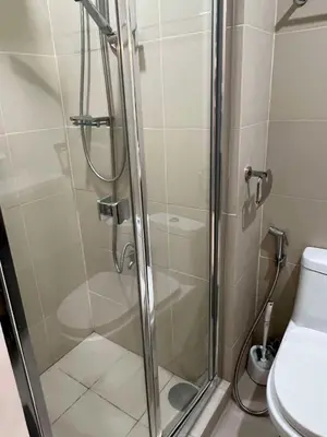 a shower stall in a bathroom with a toilet at The Lay-by Fame MRT Megamall Greenfield Greenhills in Manila