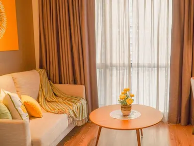 a living room with a couch and a table with a vase of flowers at The Hotel Residences at Acqua Tower in Manila