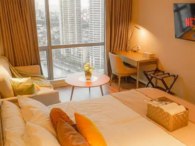 a hotel room with a bed and a large window at The Hotel Residences at Acqua Tower in Manila