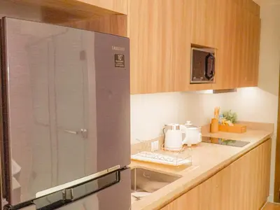 a kitchen with a sink and a refrigerator at The Hotel Residences at Acqua Tower in Manila
