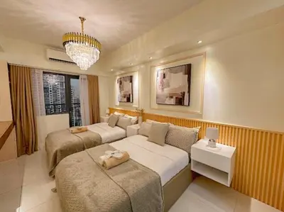a bedroom with two beds and a couch and a chandelier at Cozy Twin Suite with Balcony in Makati Free WiFi in Manila