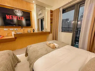 a hotel room with a bed and a television at Cozy Twin Suite with Balcony in Makati Free WiFi in Manila