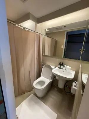 a bathroom with a toilet and a sink at Makati City Antel Spa Residences 9B in Manila