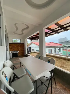a white table and chairs in a room with windows at Peaceful Port Away From Home in Manila