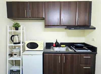 a small kitchen with a sink and a microwave at Studio unit near BGC and Makati in Manila