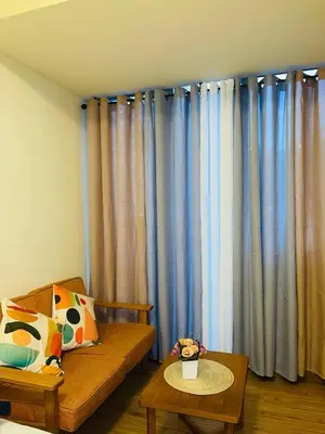 a living room with blue curtains and a couch at Azure Urban Resorts by Rhome in Manila