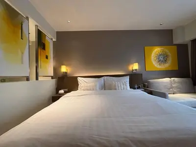 a bedroom with a large white bed with two pillows at Hotel Residences At Acqua in Manila