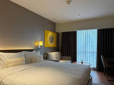 a hotel room with a large bed and a chair at Hotel Residences At Acqua in Manila
