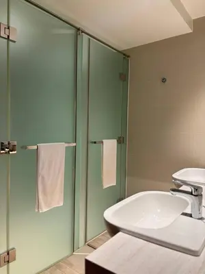 a bathroom with a sink and a toilet and a shower at The Hotel Residences at Acqua in Manila
